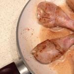 Chicken legs in a frying pan with gravy